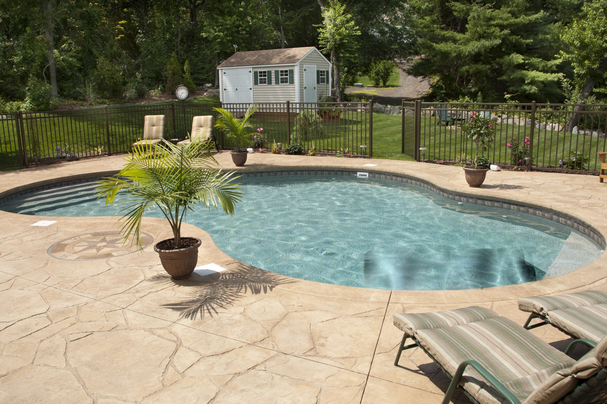 Backyard pool with stamped concrete deck and decorative compass design